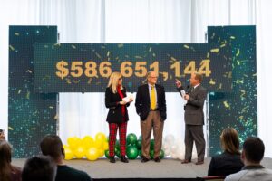 The final total for the In Our Hands campaign, with John Glover, President Bresciani, and Kristi Hanson discussing the campaign's impact