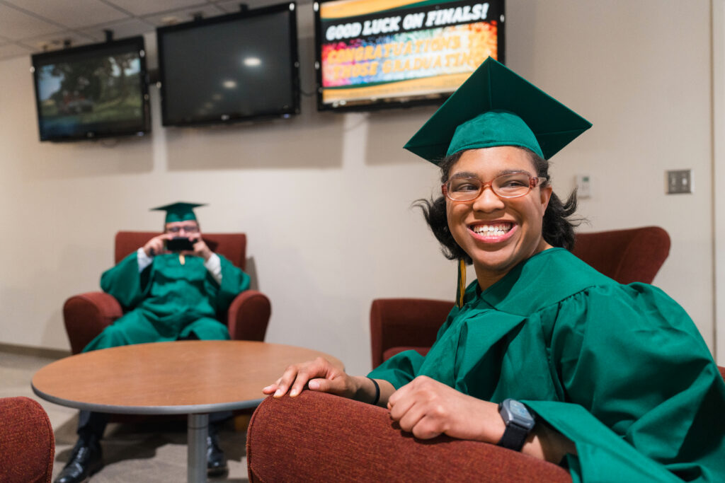 NDSU Transition and Access Program graduates smiling while getting ready to walk at graduation.
