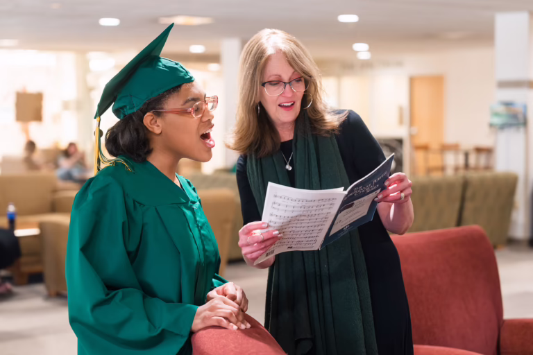 Alexander and her choir director, Dr. Charlette Moe, warm up together before performing a song at the TAP graduation ceremony.